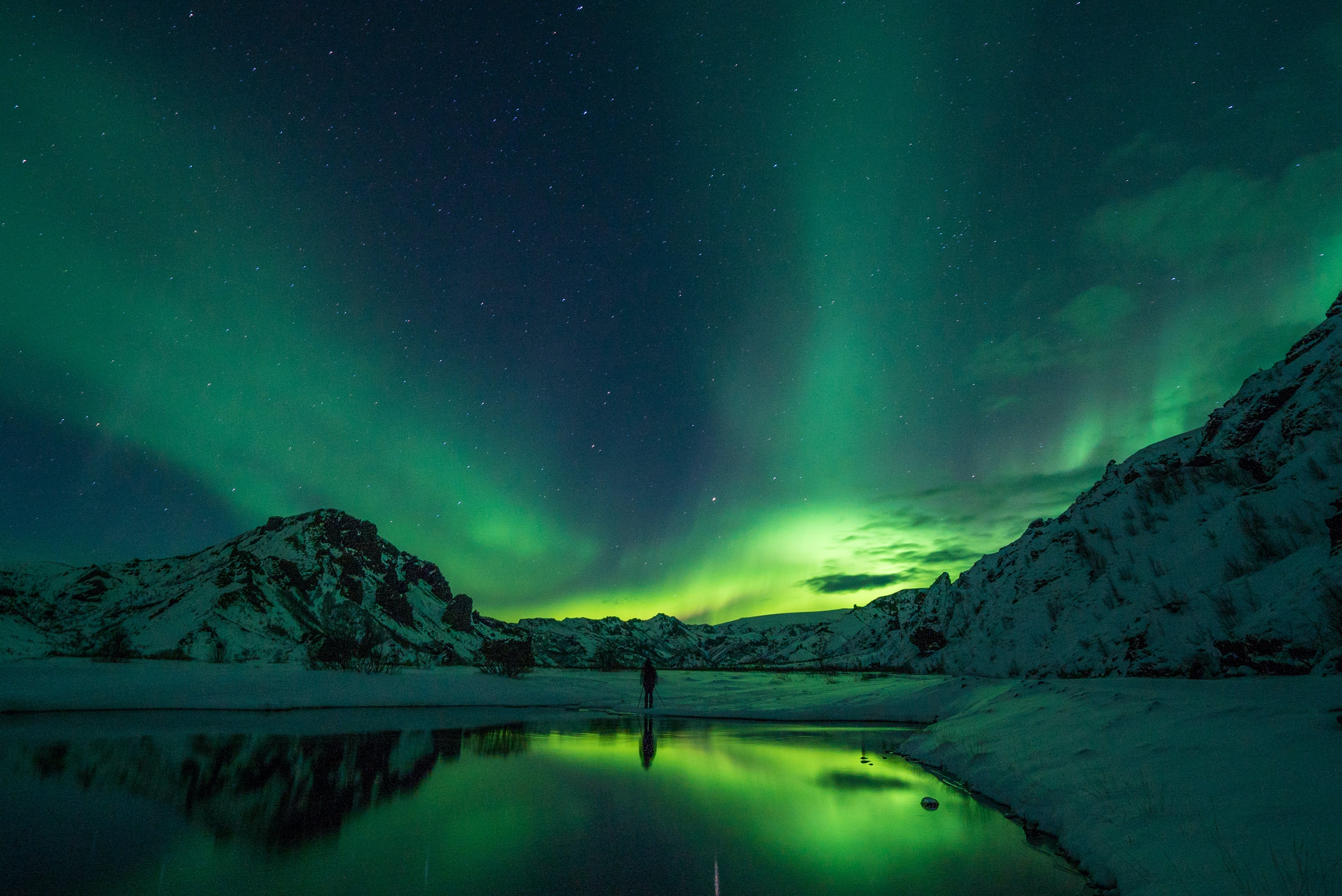 northern lights over mountains and lake